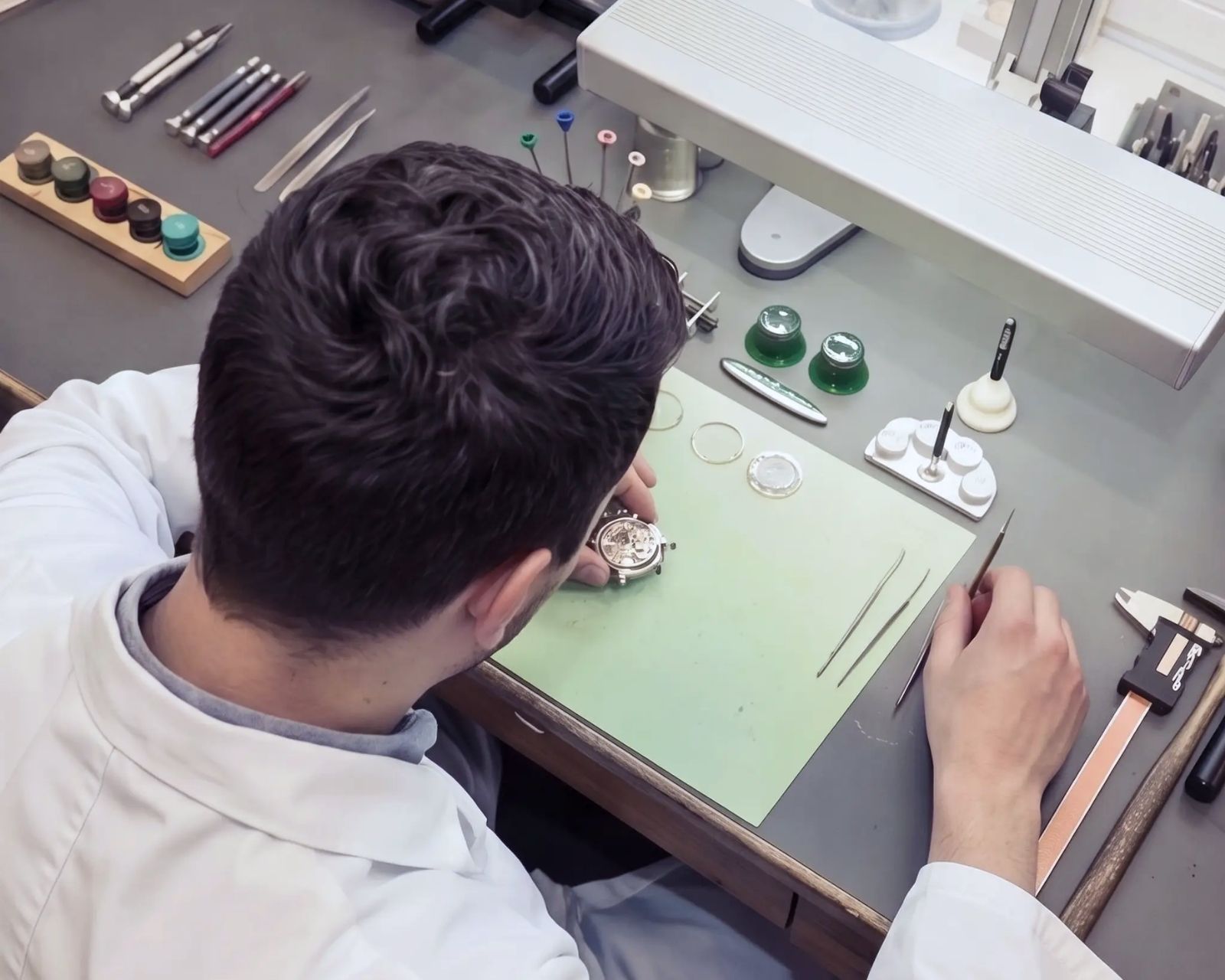Feinhandwerk an Schmuck und Uhren unter einer Lupenleuchte