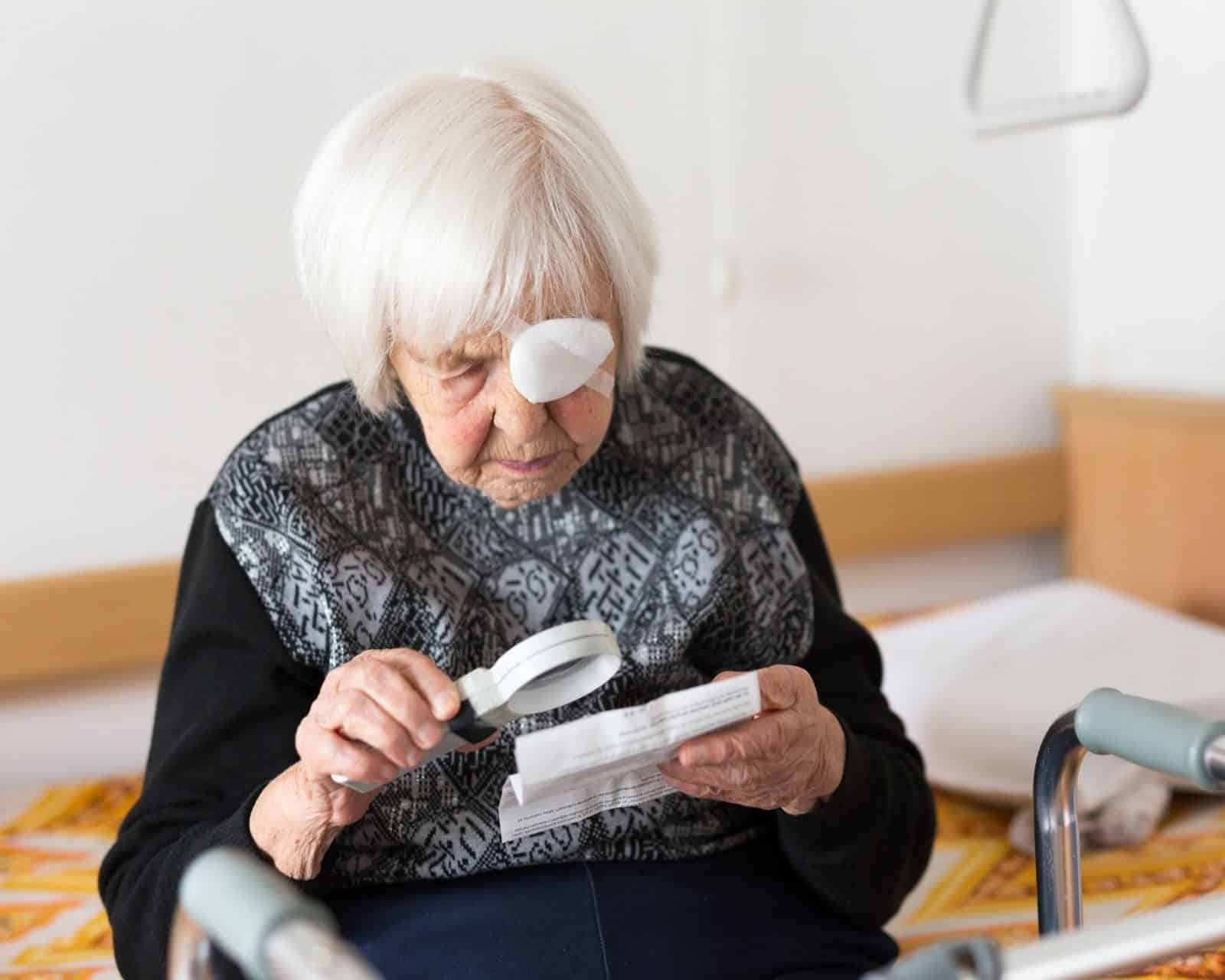 Ältere Frau liest mit Lupe unter einer hellen LED-Leseleuchte